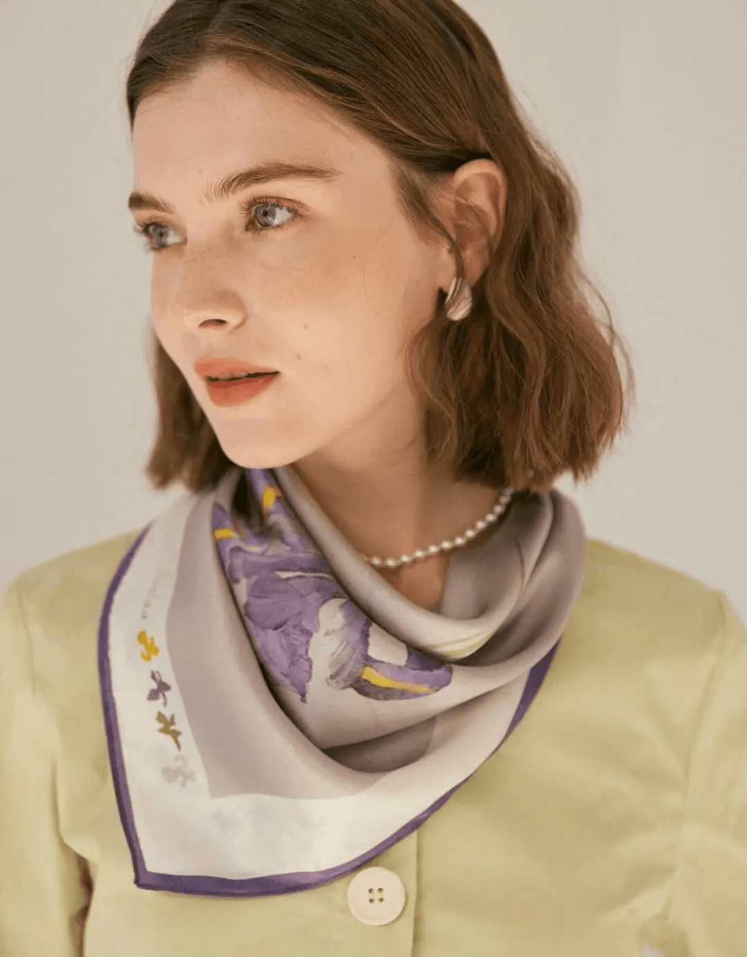 Woman wearing a fluid silk satin scarf as an elegant fashion accessory