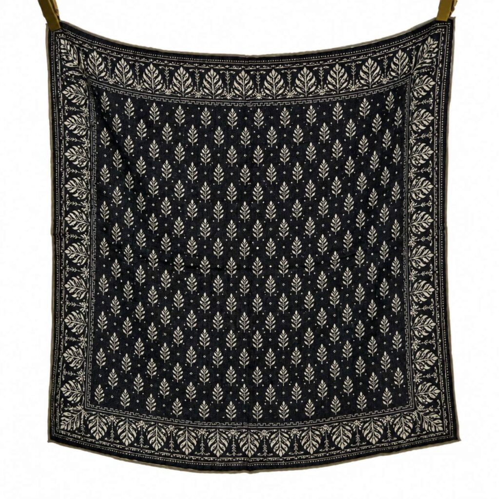 Black square scarf with ivory leaf print, featuring a repeated small leaf pattern in the center and a decorative leafy border.