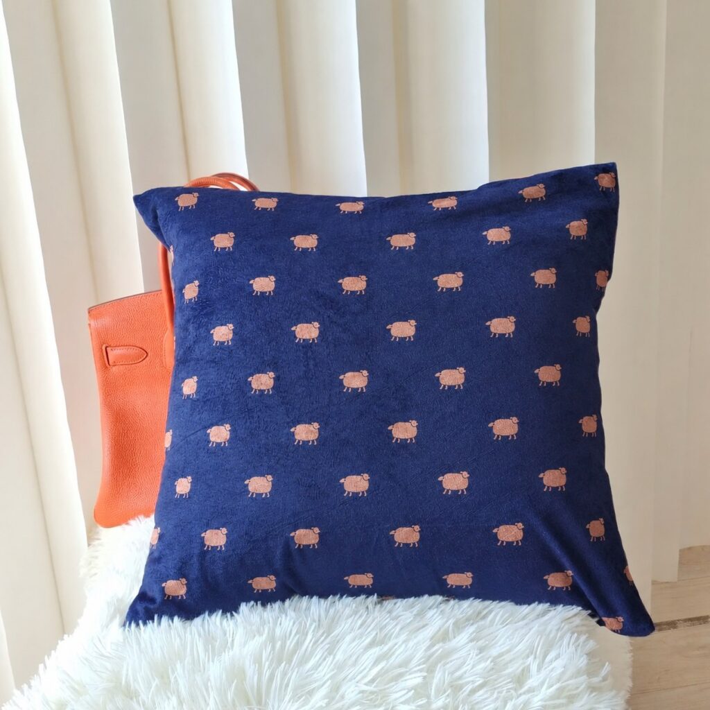 The navy flannel pillowcase contrasts beautifully with the orange handbag, while the sheep pattern adds a warm and charming home décor feel.