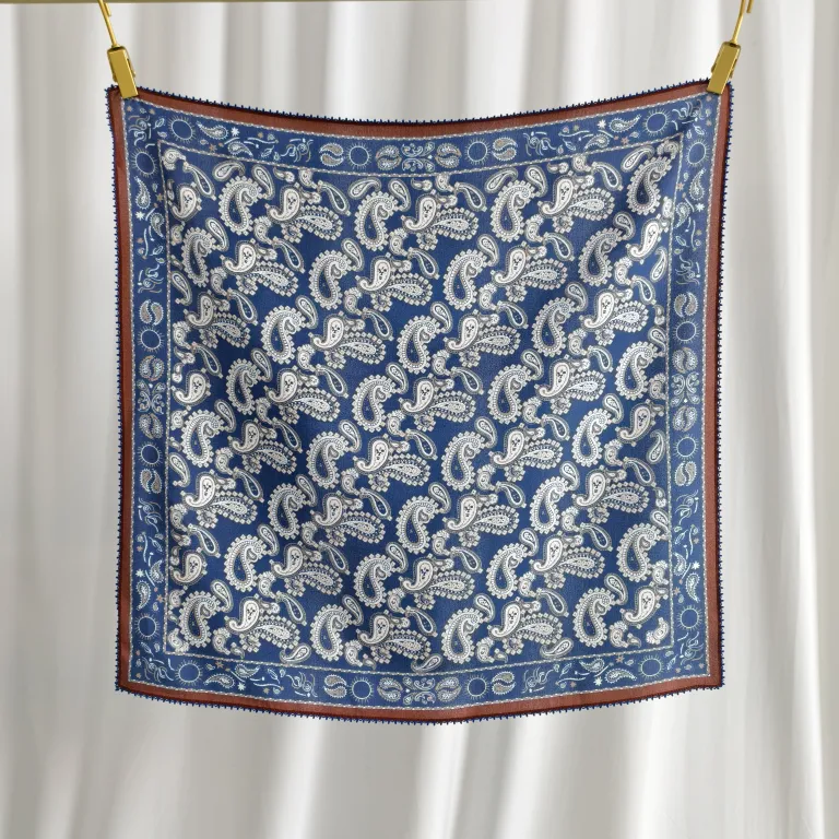 Blue paisley printed mulberry silk square scarf with a brown border and delicate lace trim.