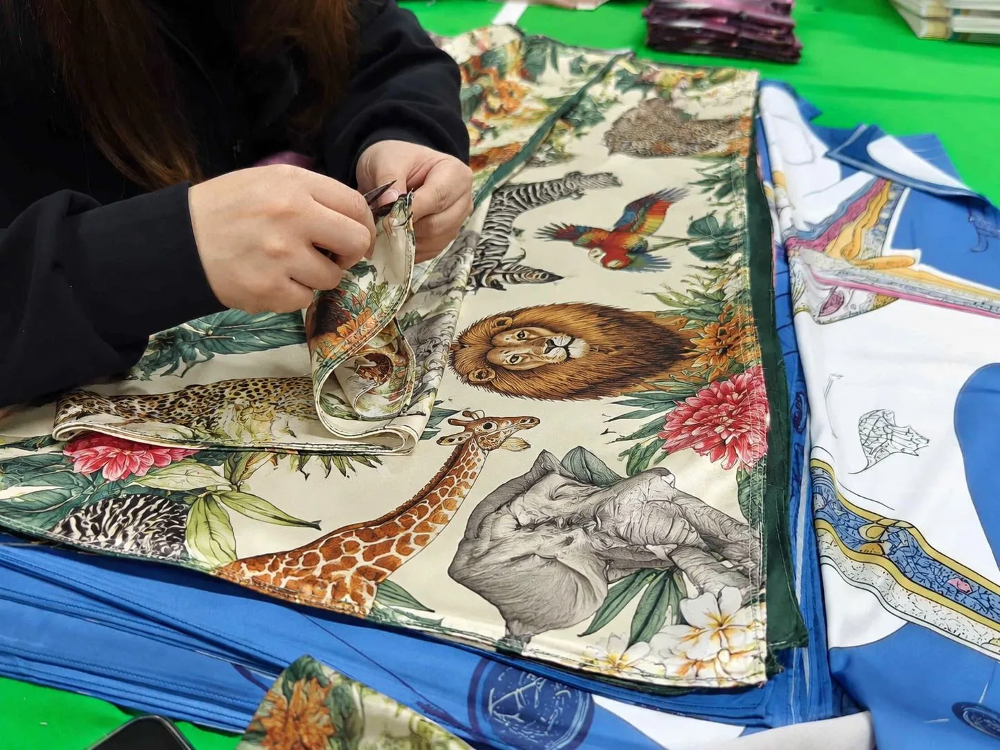 Final quality inspection of a custom printed silk scarf before packing